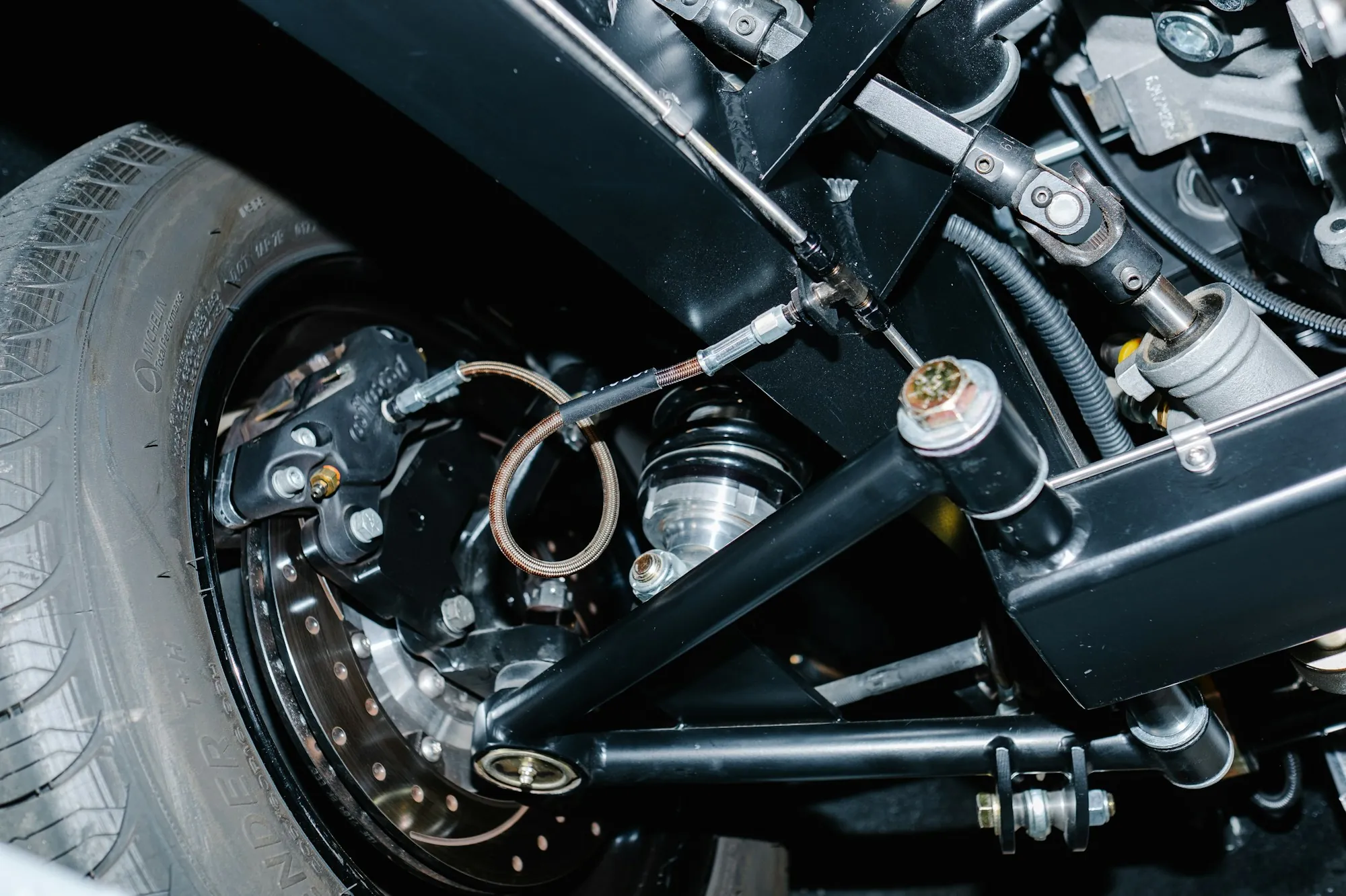 Close view of a front suspension assembly with control arm and wheel hub